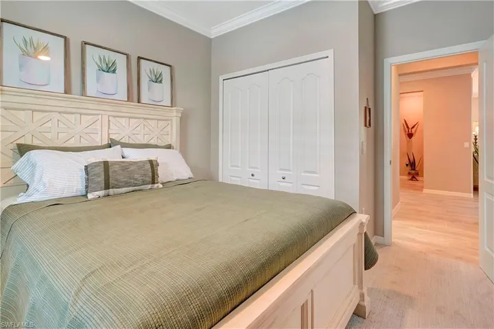 Bedroom featuring crown molding, a closet, and light wood-type flooring