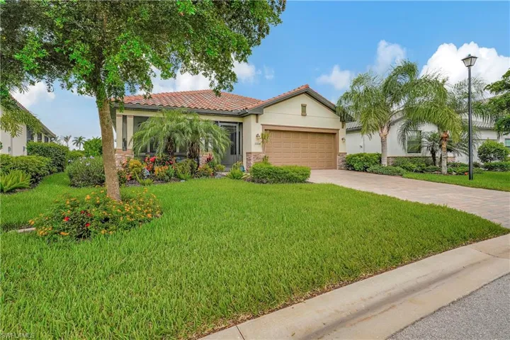 Mediterranean / spanish-style house with a garage and a front yard