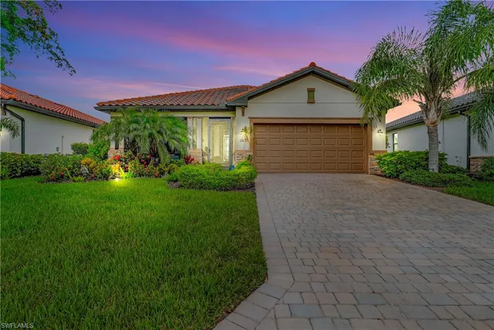 View of front of property with a garage and a yard