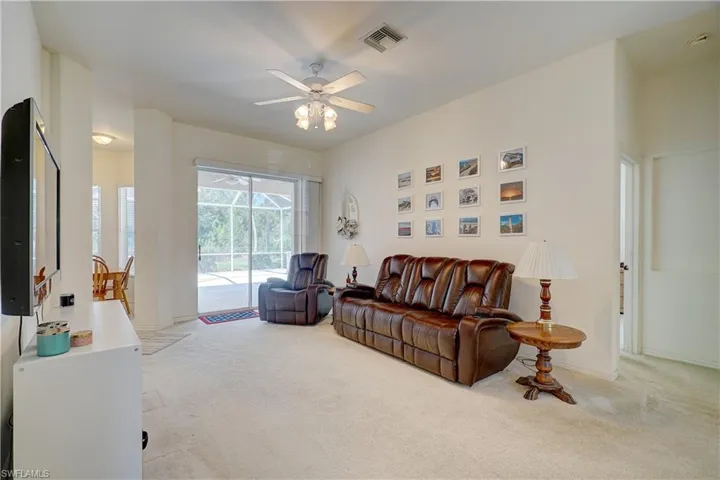 Living room with light carpet and ceiling fan