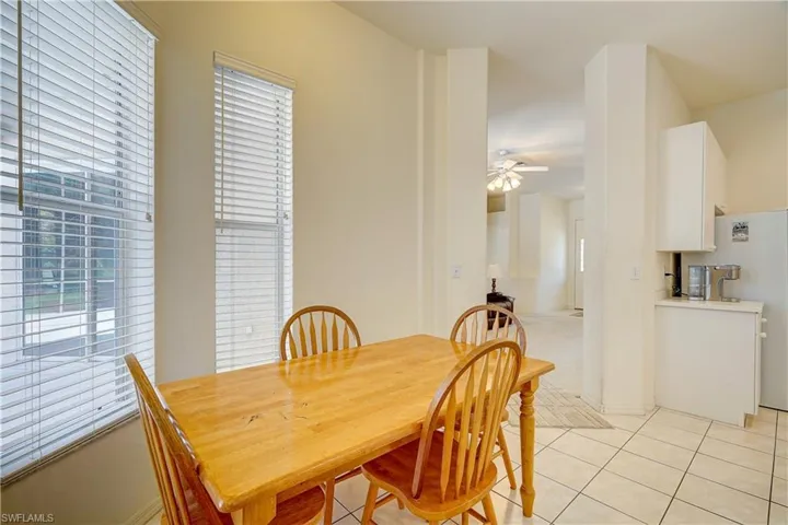 Tiled dining space with plenty of natural light and ceiling fan