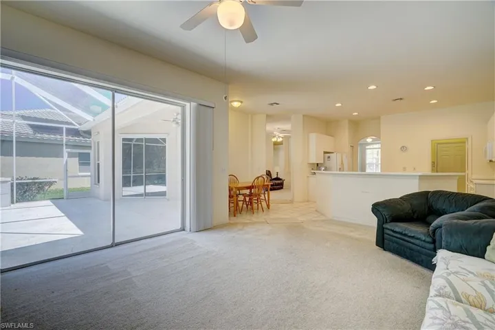 Carpeted living room with ceiling fan