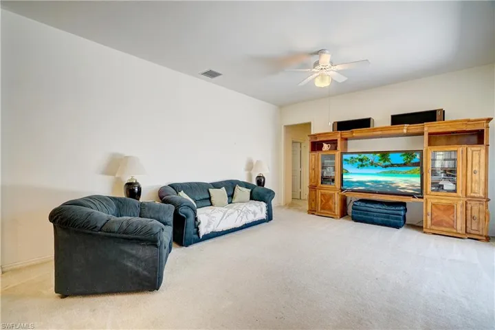 Living room featuring carpet floors and ceiling fan
