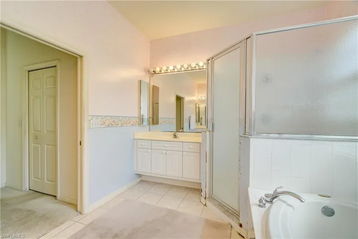 Master bathroom featuring tile floors, shower with separate bathtub, and vanity