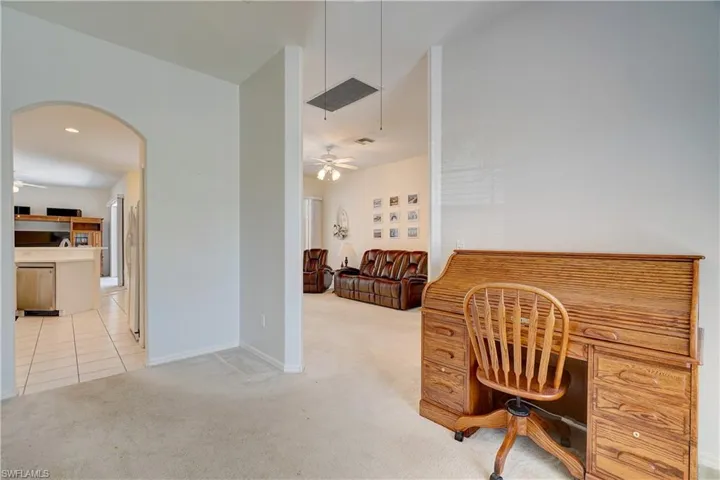 Carpeted office featuring ceiling fan