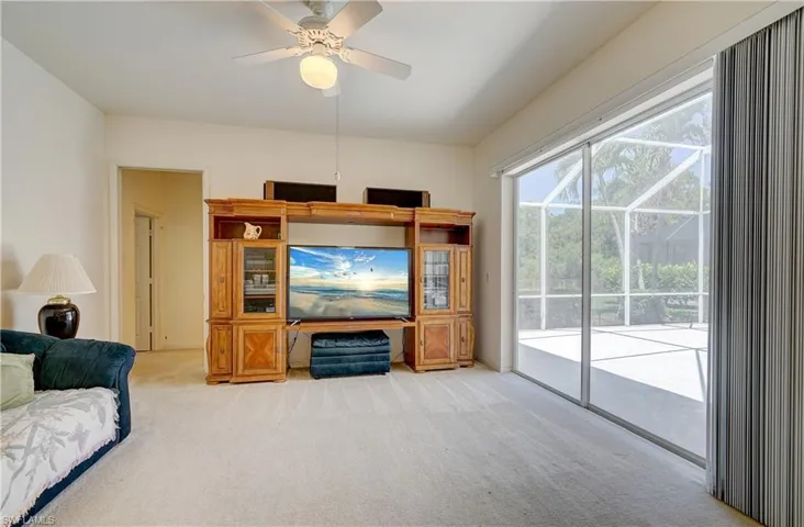 Carpeted living room featuring ceiling fan