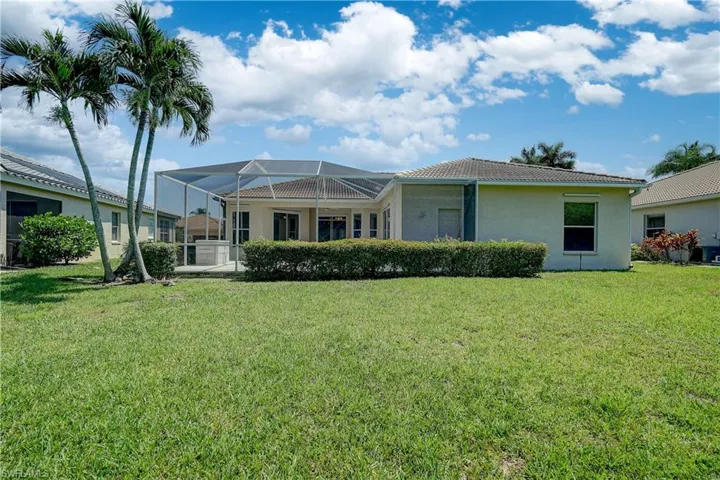 Back of property featuring a yard and a lanai