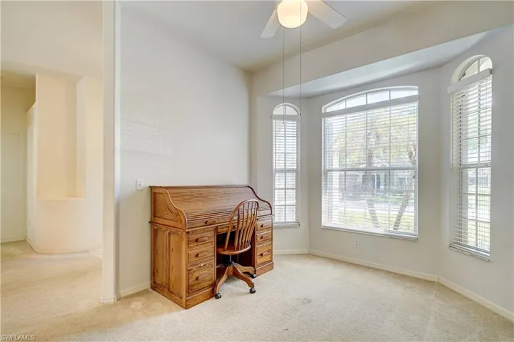 Carpeted office space featuring ceiling fan