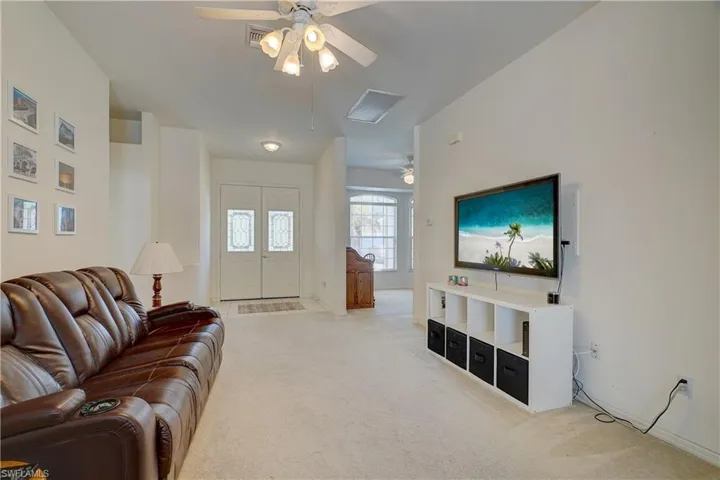 Living room with ceiling fan and light colored carpet