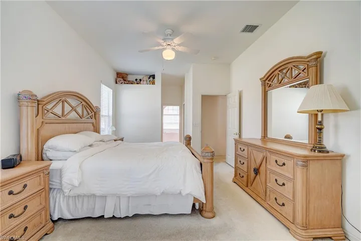 Carpeted master featuring ceiling fan