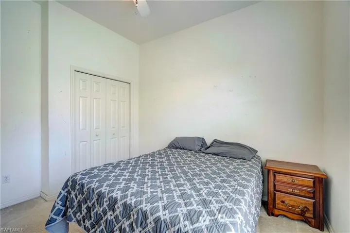 Carpeted bedroom featuring a closet and ceiling fan