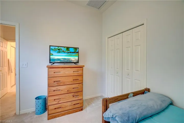 Carpeted bedroom with a closet