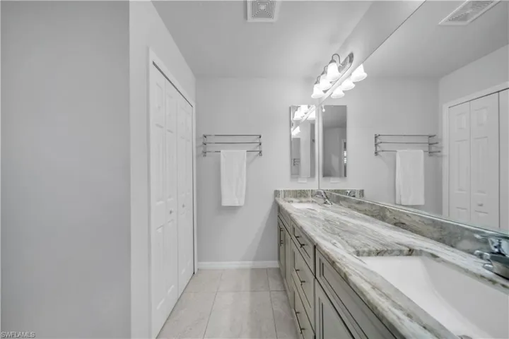 Full bath featuring a closet and double vanity