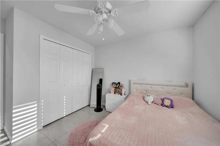 Bedroom featuring ceiling fan, a closet, and light tile patterned floors