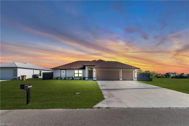 Prairie-style home featuring an attached garage, roof with shingles, a front lawn, and concrete driveway