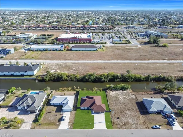 Aerial overview of property's location with nearby suburban area and a nearby body of water