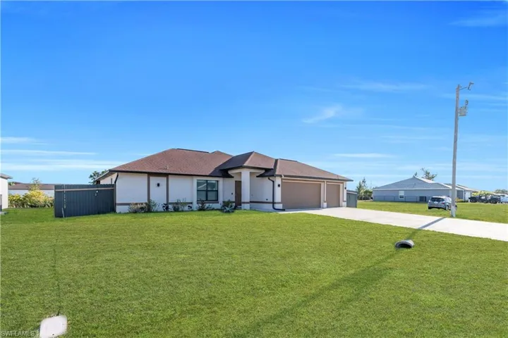Prairie-style house with a front yard, concrete driveway, stucco siding, and a garage