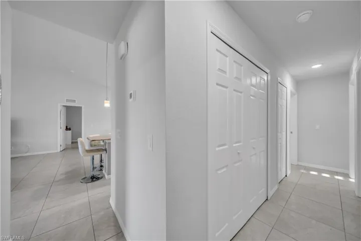 Corridor featuring light tile patterned flooring and baseboards