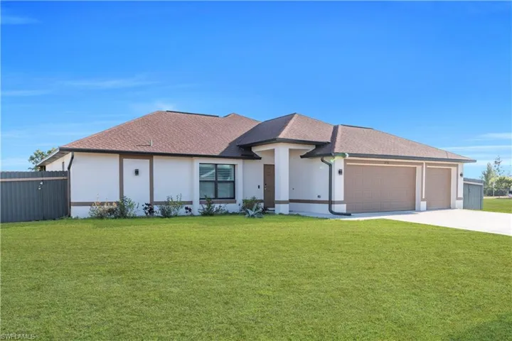 View of front of home with stucco siding, a shingled roof, an attached garage, and driveway