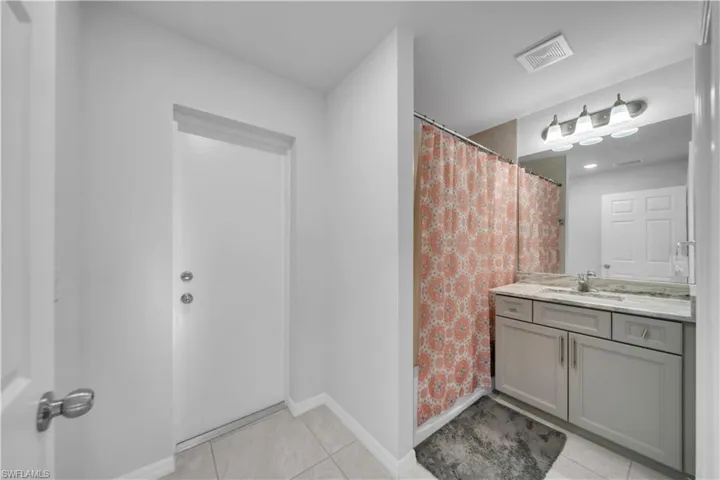 Bathroom featuring vanity, a shower with shower curtain, and light tile patterned floors