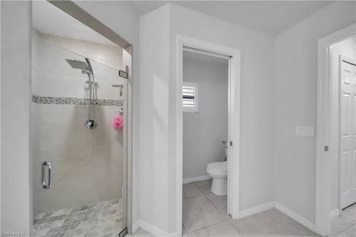 Full bath featuring a stall shower and toilet