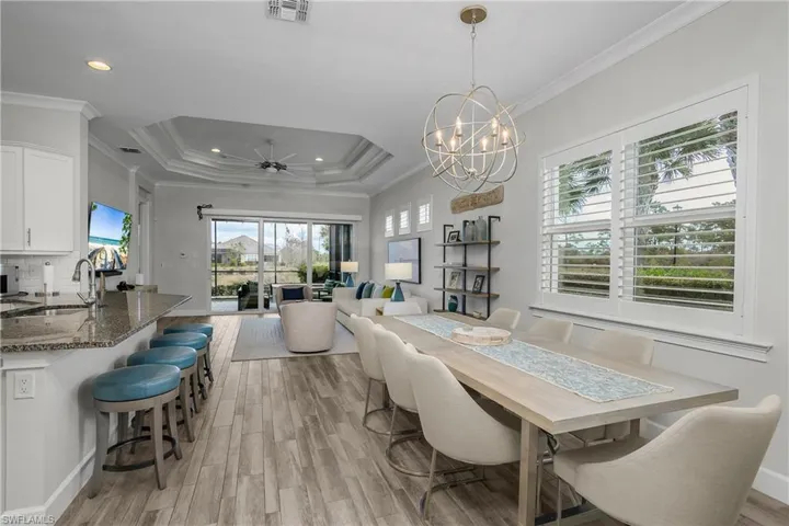 Dining space with a ceiling fan, crown molding, a chandelier, and a raised ceiling, Plantation Shutters