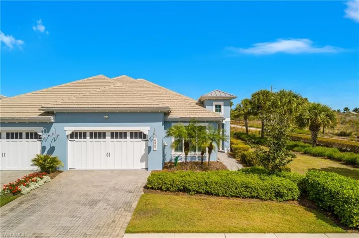 View of front of house with decorative driveway, a garage, stucco siding, a front lawn, and a tile roof. No neighbors on the right!