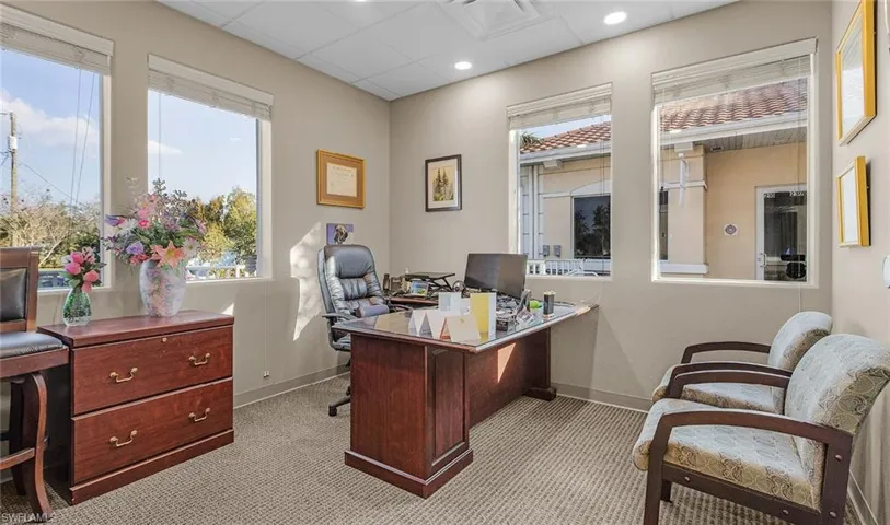 Office area featuring recessed lighting, baseboards, a drop ceiling, and light colored carpet