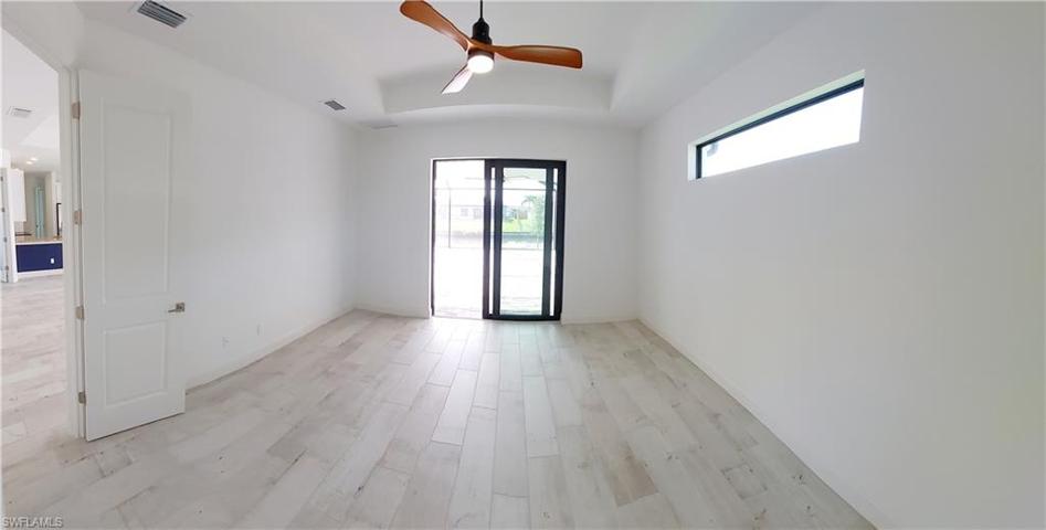 Master bedroom with tray ceiling and impact slider to the lanai.