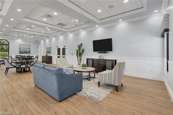 Living room with ceiling fan, light hardwood / wood-style flooring, and crown molding