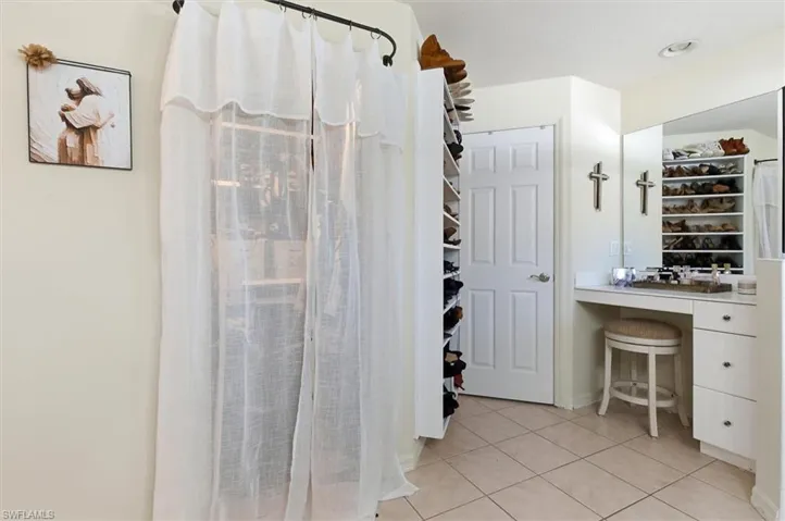 Full bathroom featuring a shower stall and light tile patterned flooring