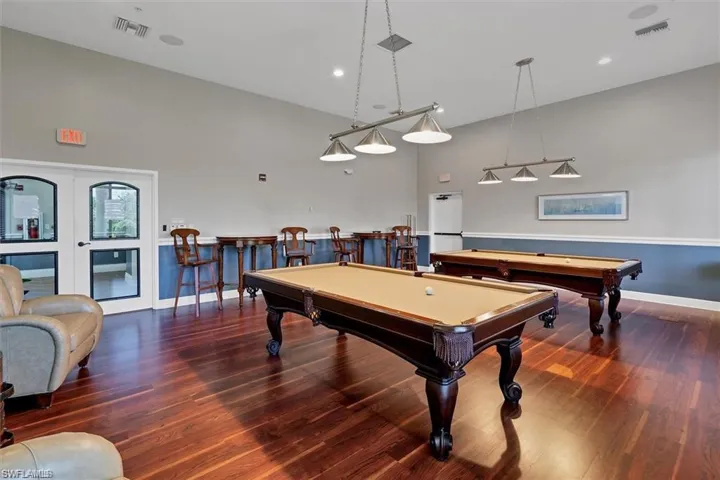 Playroom featuring billiards, high vaulted ceiling, dark hardwood / wood-style flooring, and indoor bar