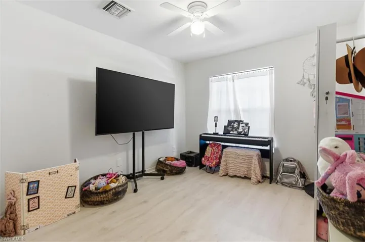 Game room with wood finished floors and ceiling fan