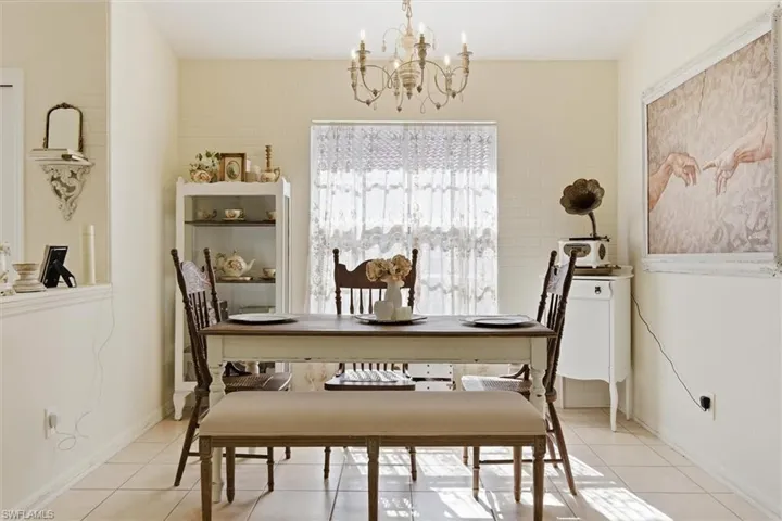 Tiled dining room with a chandelier