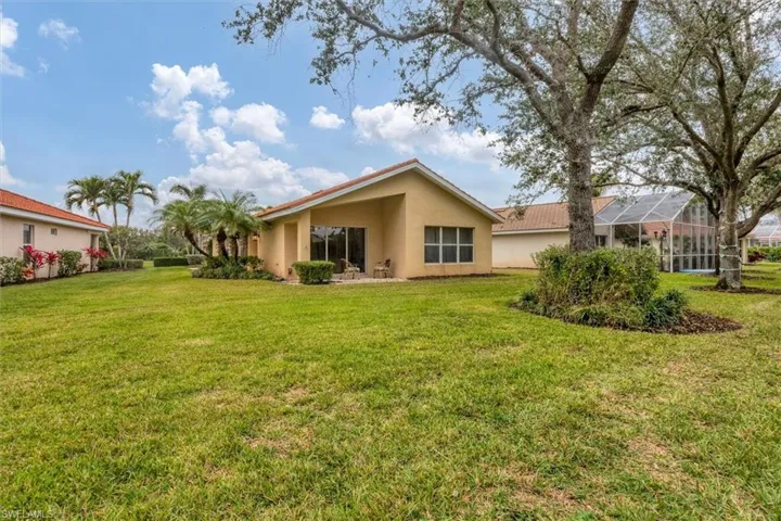 Back of property featuring a lawn and a lanai