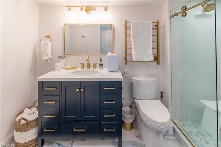 Full bathroom with vanity, a stall shower, and light marble finish floors