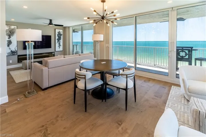 Dining area with light wood-style flooring, a chandelier, recessed lighting, a ceiling fan, and expansive windows