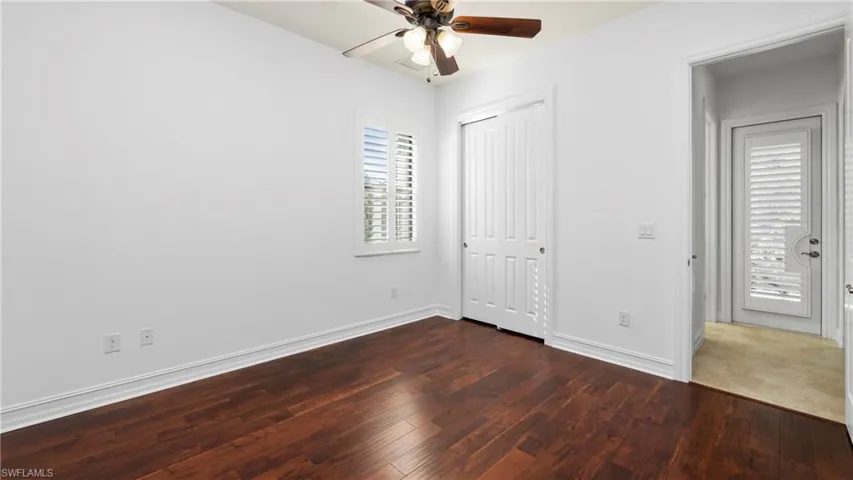 Unfurnished bedroom with dark wood-type flooring, ceiling fan, and a closet