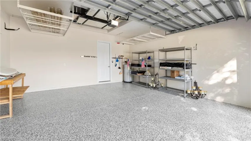 Garage featuring water heater and a garage door opener