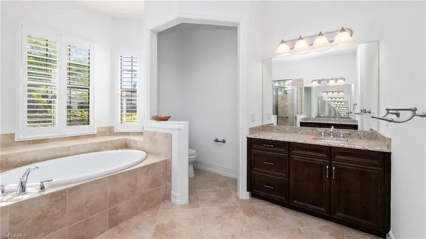 Full bath with vanity, a stall shower, a garden tub, and light tile patterned floors