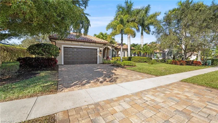 Mediterranean / spanish-style house with a front lawn, decorative driveway, a garage, and stucco siding