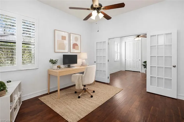 Virtually Staged Home office with a ceiling fan, dark wood-type flooring, and french doors