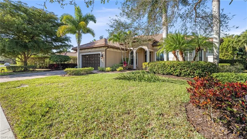 Mediterranean / spanish-style home with stucco siding, a garage, a tiled roof, a front yard, and asphalt driveway