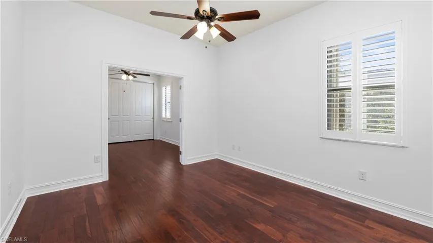 Empty room featuring dark wood-style floors and ceiling fan