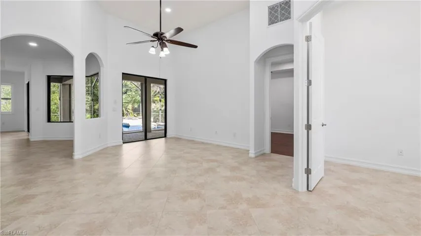 Spare room featuring arched walkways, a high ceiling, ceiling fan, and recessed lighting