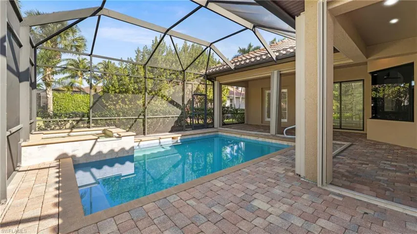 Outdoor pool featuring a patio area, a sunroom, and a lanai