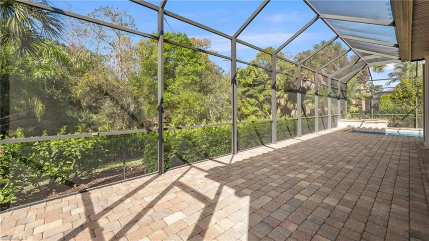 View of patio with a sunroom, glass enclosure, and a swimming pool