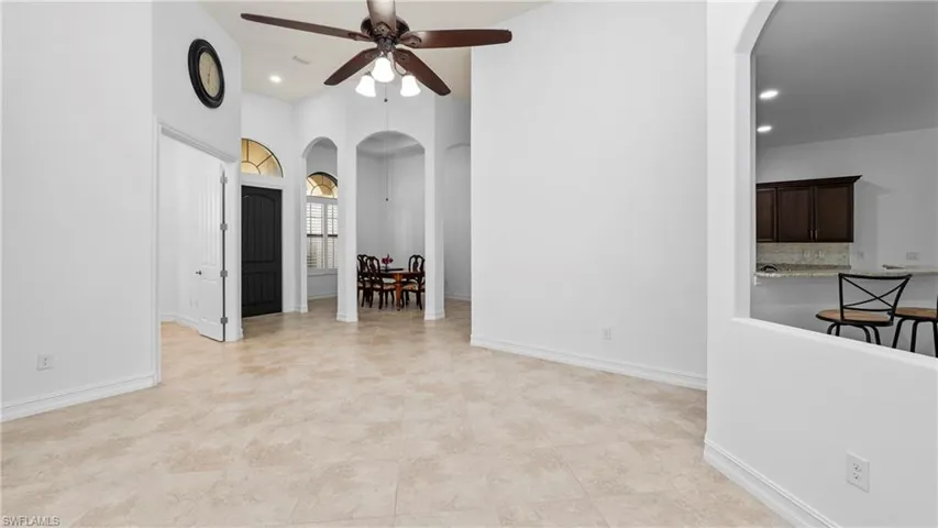 Spare room featuring arched walkways, ceiling fan, recessed lighting, and a high ceiling