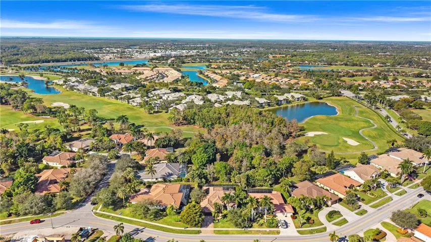 Aerial view of residential area with a golf course and a nearby body of water