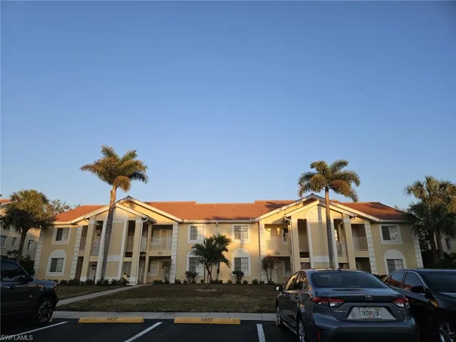 View of apartment building / complex with uncovered parking